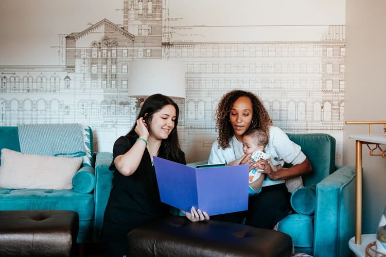 Care provider holding a baby and smiling